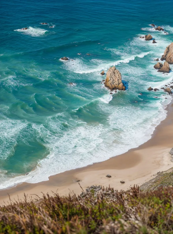 Praia da Ursa near Cabo da Roca in Portugal, with golden sand, turquoise waves, and dramatic rock formations — a hidden gem on IzzyTrip’s Portugal tours.